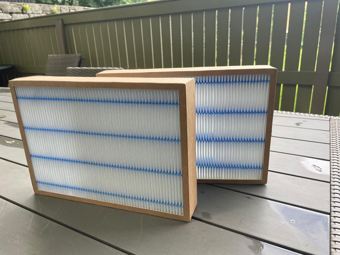 Kaks puhast AIROX ventilatsioonifiltrit valgete plisseeritud paneelidega